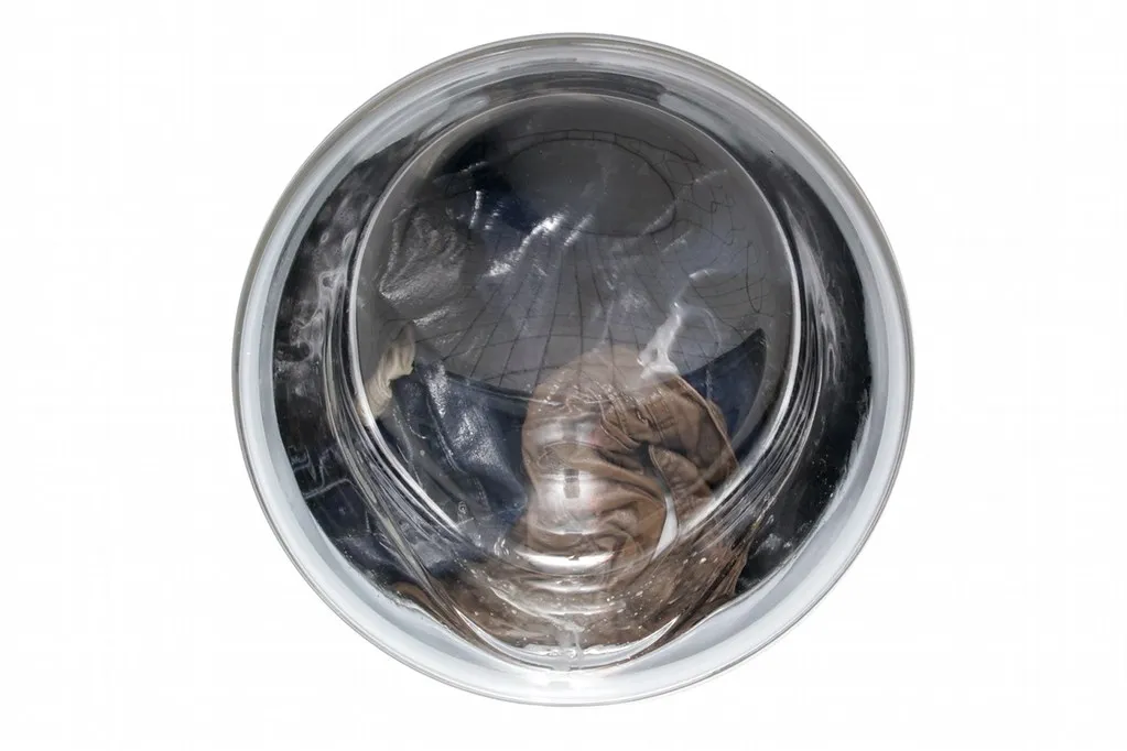 Clothes turning behind the round glass door of a front-loading washing machine